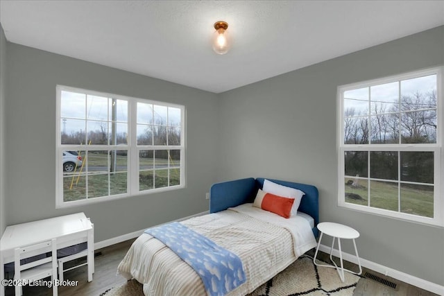 bedroom featuring wood-type flooring and multiple windows