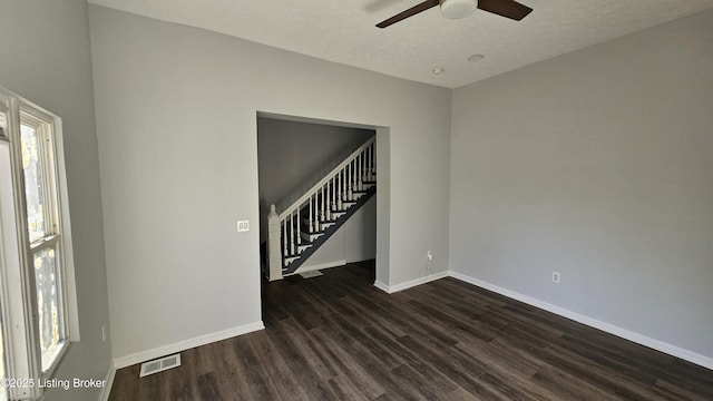 spare room with dark hardwood / wood-style flooring, ceiling fan, and a textured ceiling