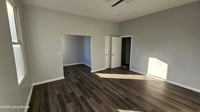 empty room with dark wood-type flooring and ceiling fan