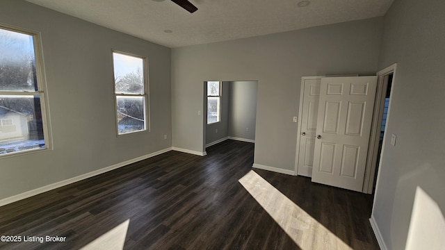 spare room with dark hardwood / wood-style flooring, ceiling fan, and a textured ceiling