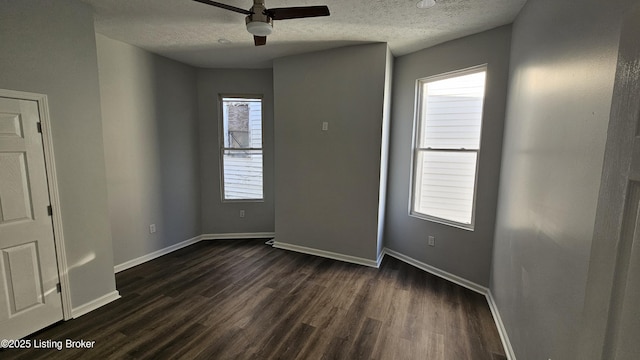 unfurnished room featuring dark hardwood / wood-style flooring, ceiling fan, plenty of natural light, and a textured ceiling