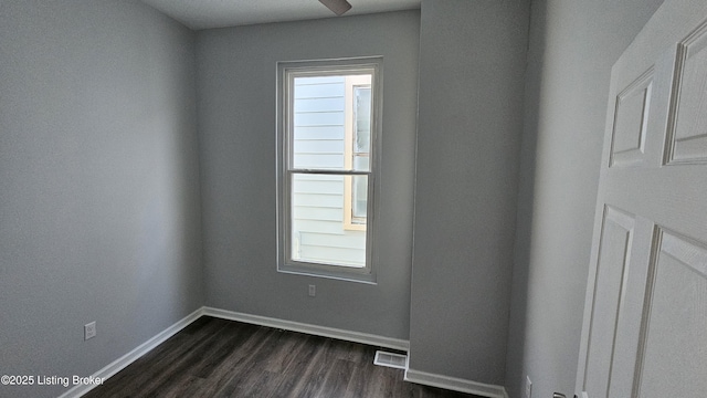 empty room featuring dark wood-type flooring and a healthy amount of sunlight