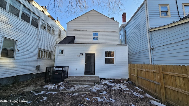 snow covered back of property with central AC