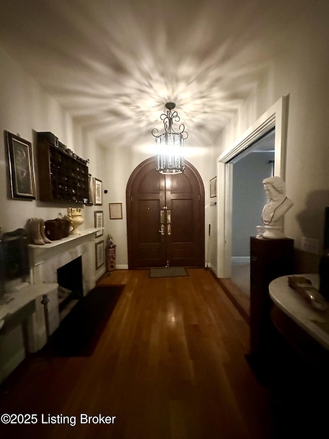 hallway featuring an inviting chandelier and hardwood / wood-style floors