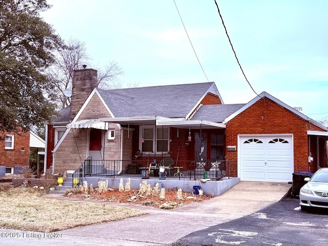 view of front of property with a chimney, covered porch, concrete driveway, an attached garage, and stone siding