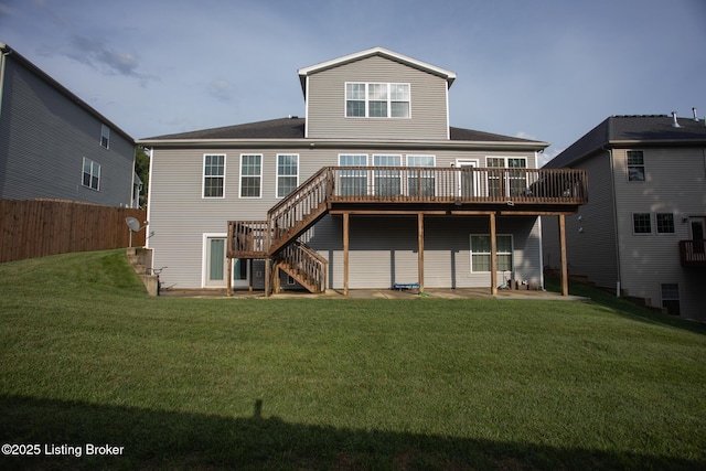 rear view of house featuring a patio, a deck, and a lawn