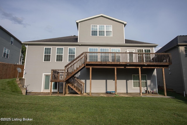 back of house featuring a wooden deck, a patio area, and a lawn