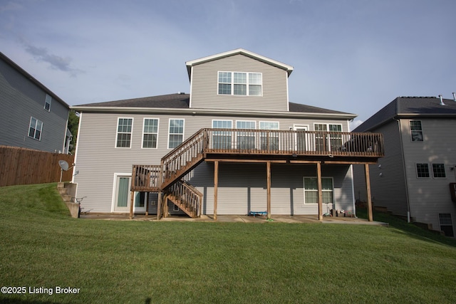 rear view of property featuring a patio, a deck, and a lawn