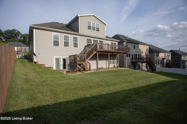 back of house with a deck and a lawn