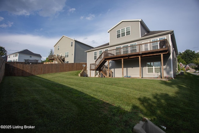 rear view of house with a wooden deck and a lawn