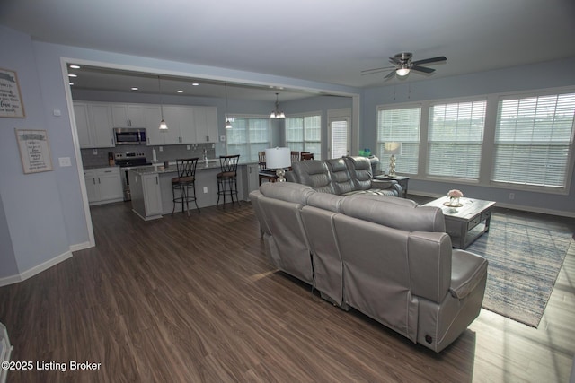 living room with dark wood-type flooring and ceiling fan