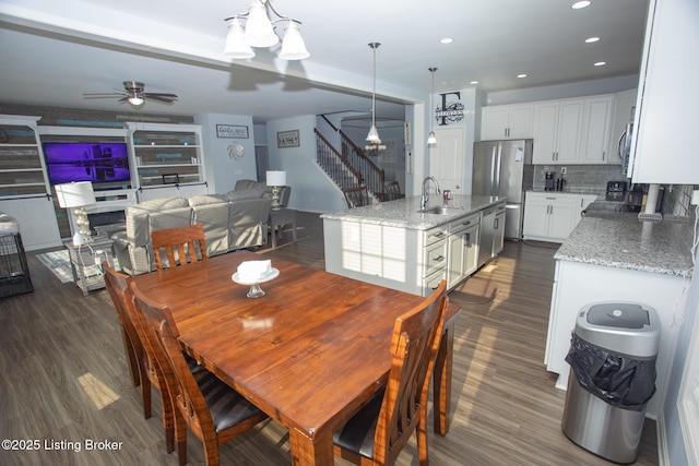 dining room featuring sink, ceiling fan with notable chandelier, and dark hardwood / wood-style floors