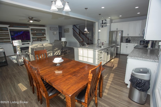 dining area featuring dark wood-type flooring, ceiling fan, and sink