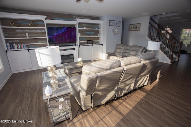 living room with wood-type flooring, ceiling fan, and built in shelves