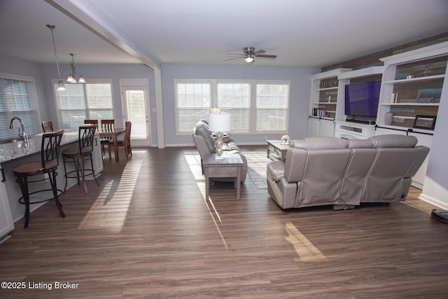 living room with sink, dark wood-type flooring, and ceiling fan with notable chandelier