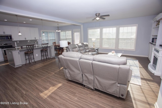 living room featuring dark hardwood / wood-style flooring and ceiling fan