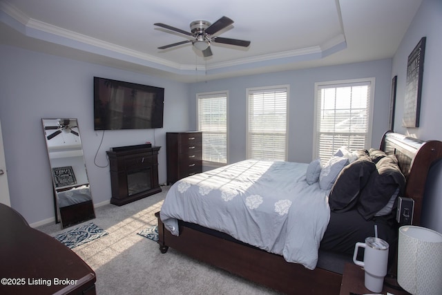 bedroom featuring light carpet, crown molding, a raised ceiling, and ceiling fan