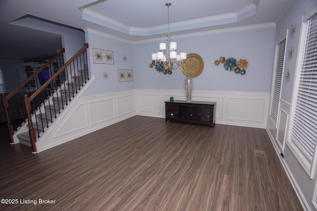 interior space with a raised ceiling, crown molding, dark hardwood / wood-style floors, and a chandelier