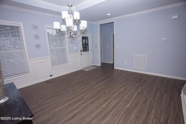 unfurnished room featuring crown molding, dark hardwood / wood-style flooring, and an inviting chandelier