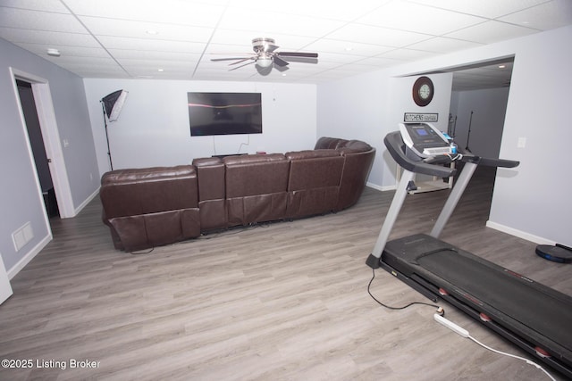 workout room featuring a paneled ceiling, ceiling fan, and light hardwood / wood-style flooring