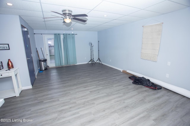 empty room featuring ceiling fan, wood-type flooring, and a drop ceiling