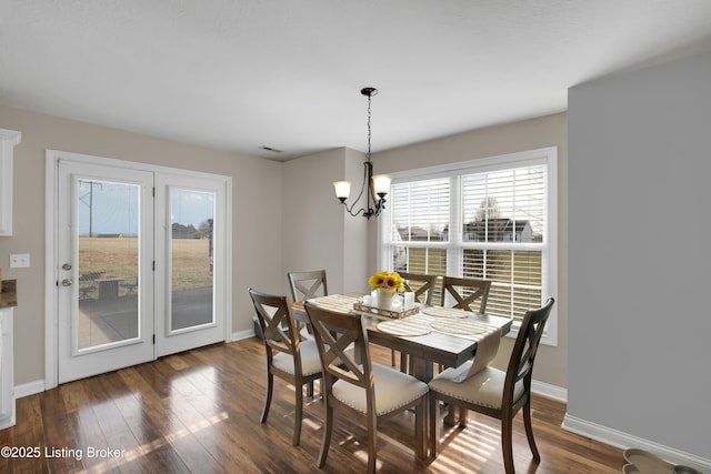 dining room featuring a notable chandelier and dark wood-type flooring