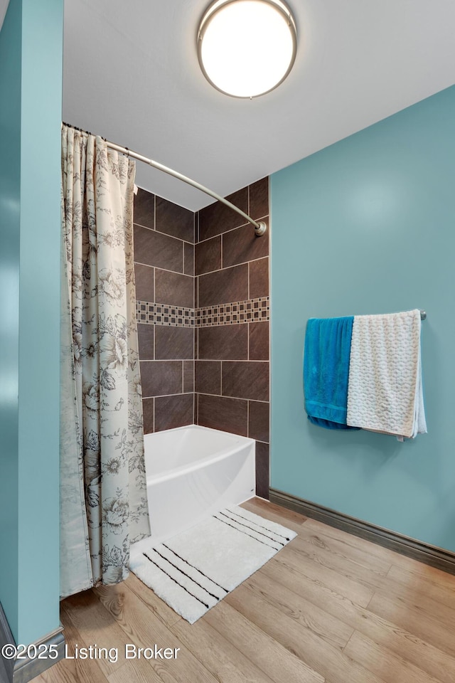 bathroom with wood-type flooring and shower / tub combo