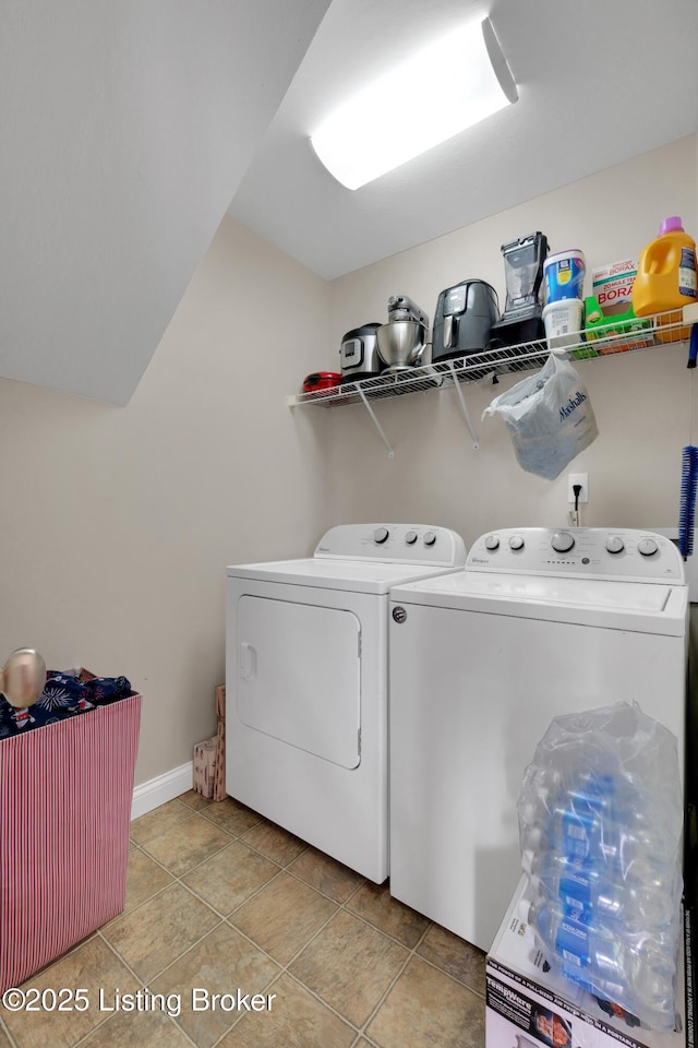 clothes washing area with washer and dryer and light tile patterned floors