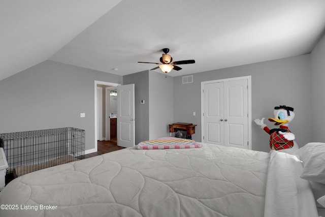 bedroom featuring hardwood / wood-style floors, vaulted ceiling, a closet, and ceiling fan