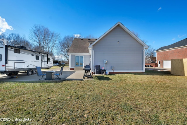 back of property with a yard and a patio area