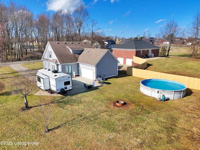 exterior space with a garage, a yard, and a fenced in pool