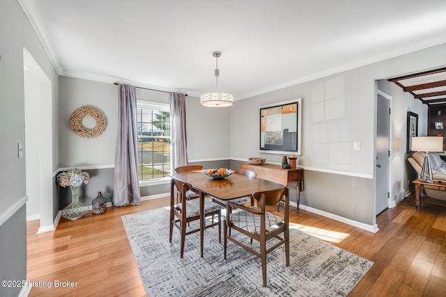 dining room with ornamental molding and light wood-type flooring