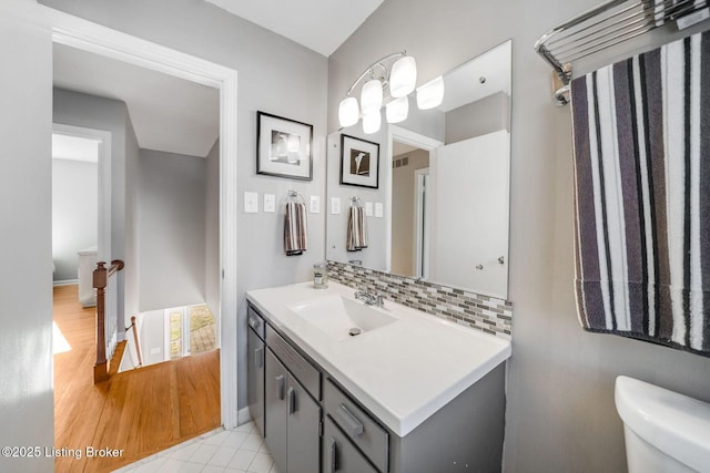 bathroom featuring tasteful backsplash, vanity, and toilet