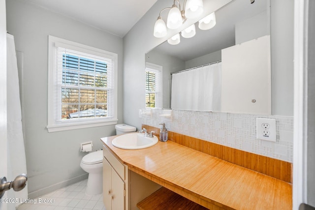 bathroom featuring tasteful backsplash, vanity, a notable chandelier, toilet, and tile patterned floors