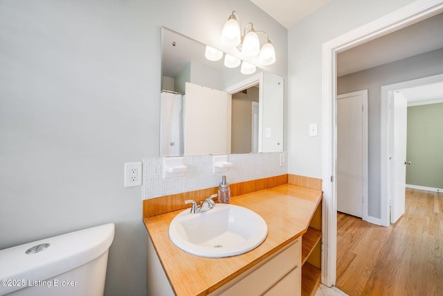 bathroom featuring vanity, decorative backsplash, toilet, and hardwood / wood-style flooring