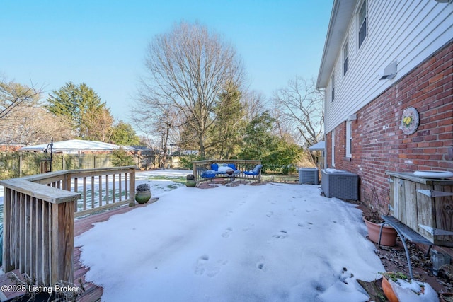 yard covered in snow featuring a deck and central air condition unit