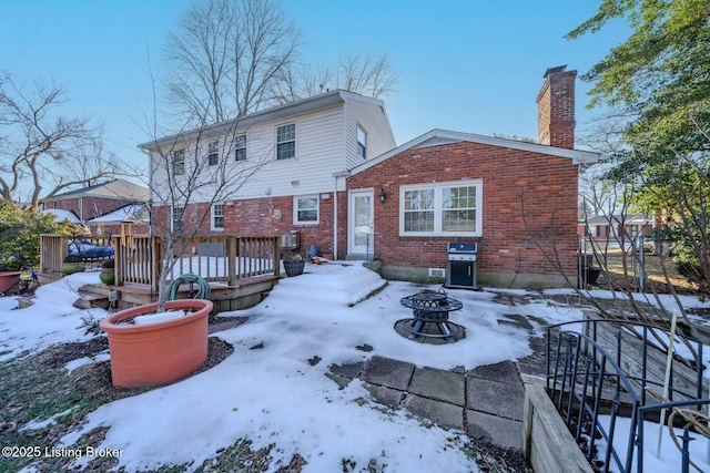 snow covered property featuring an outdoor fire pit