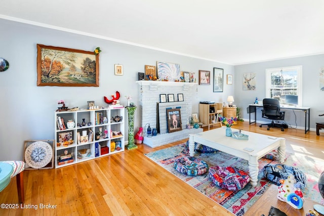 living room with a brick fireplace and hardwood / wood-style flooring