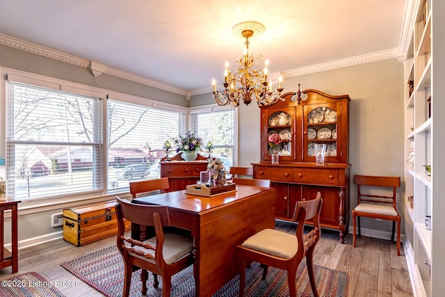 dining space featuring hardwood / wood-style flooring, ornamental molding, and a chandelier