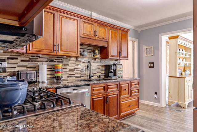 kitchen with dark stone countertops, decorative backsplash, ornamental molding, and dishwasher