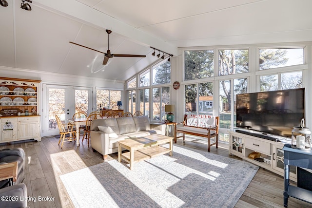 sunroom / solarium featuring lofted ceiling with beams, ceiling fan, and french doors