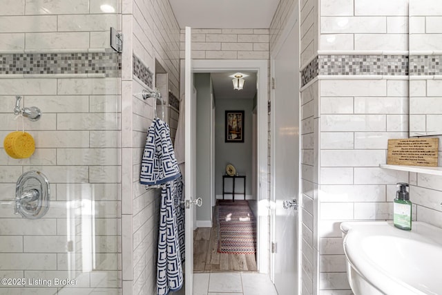 bathroom featuring tile walls and a shower