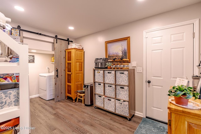 interior space with hardwood / wood-style flooring, a barn door, and washer / dryer