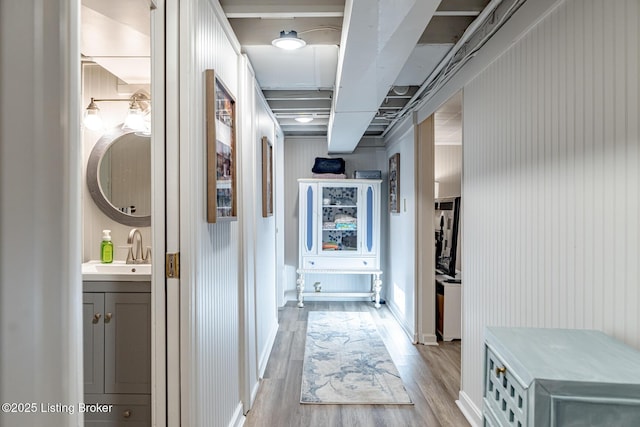 corridor featuring sink and light hardwood / wood-style floors