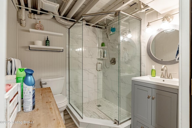 bathroom with a shower with door, vanity, hardwood / wood-style flooring, and toilet