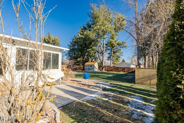 view of yard featuring a sunroom, a patio area, and a shed