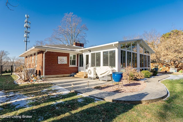 back of property featuring a patio and a sunroom