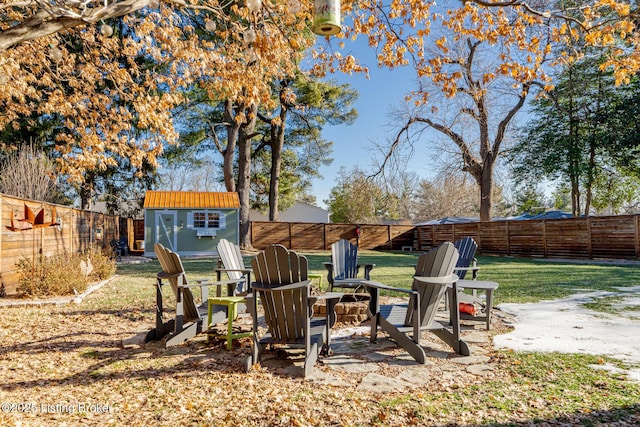 view of yard with an outdoor fire pit and a storage shed