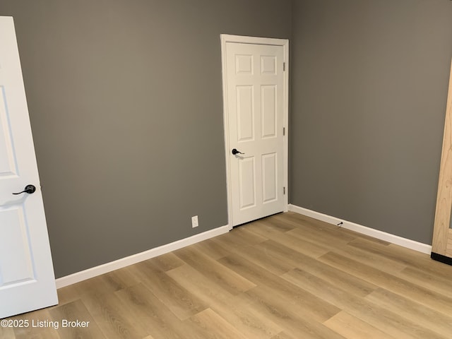 unfurnished room featuring light wood-style flooring and baseboards