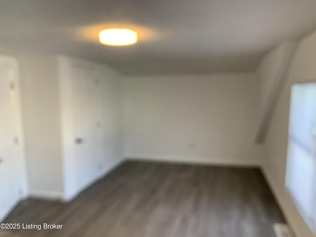 unfurnished room with dark wood-type flooring